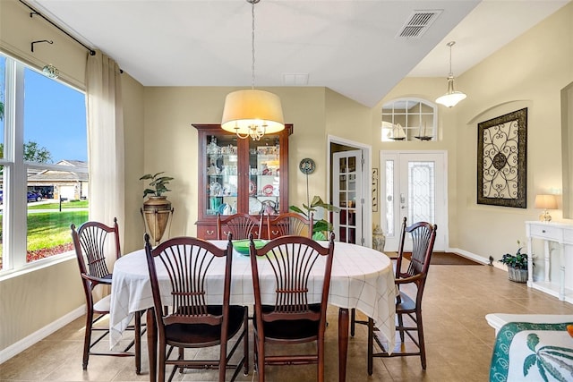 tiled dining space featuring a healthy amount of sunlight and a notable chandelier