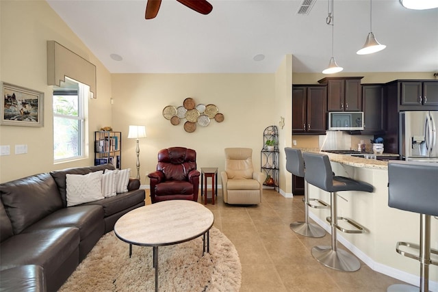 living room featuring ceiling fan, light tile patterned floors, and lofted ceiling