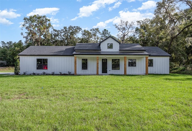 modern inspired farmhouse with a front yard and covered porch