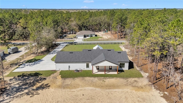 drone / aerial view featuring a wooded view