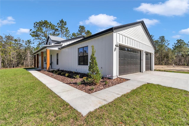 view of side of property featuring an attached garage, board and batten siding, a lawn, and concrete driveway