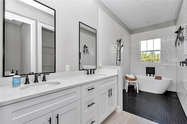 full bath with double vanity, a soaking tub, and a sink