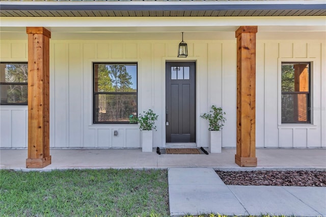 view of exterior entry featuring board and batten siding and covered porch