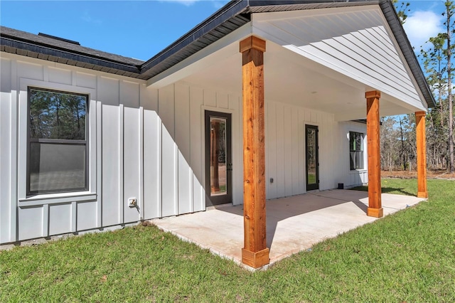 rear view of house with a patio, a yard, and board and batten siding