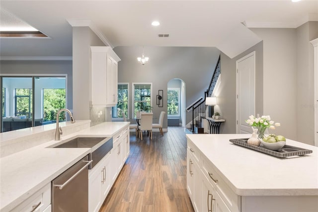 kitchen with stainless steel dishwasher, plenty of natural light, white cabinetry, and sink