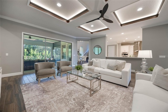 living room with ceiling fan, ornamental molding, and light wood-type flooring