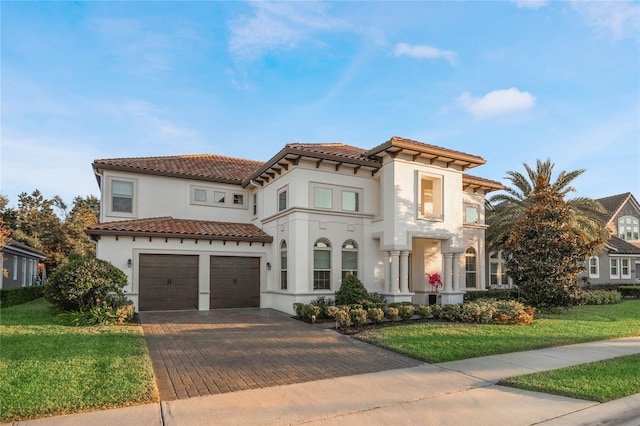 mediterranean / spanish-style home featuring a garage and a front lawn