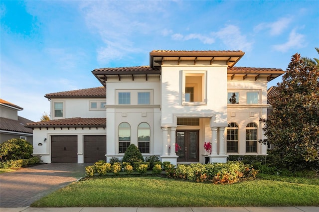 mediterranean / spanish house featuring french doors, a front yard, and a garage