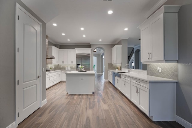 kitchen with appliances with stainless steel finishes, a kitchen island, sink, dark hardwood / wood-style floors, and white cabinetry