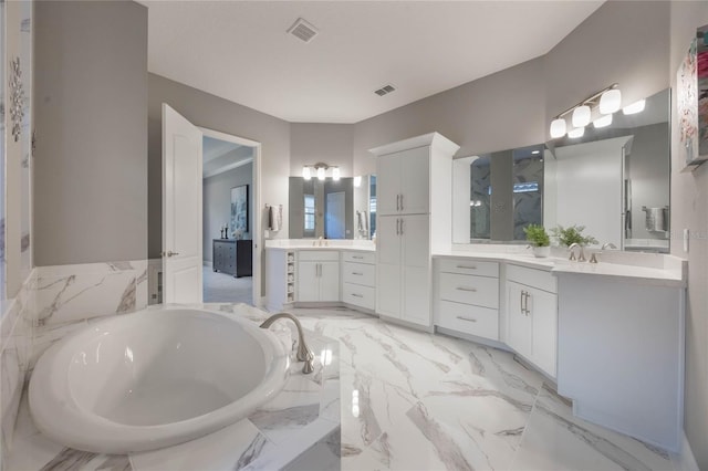 bathroom featuring vanity and tiled bath