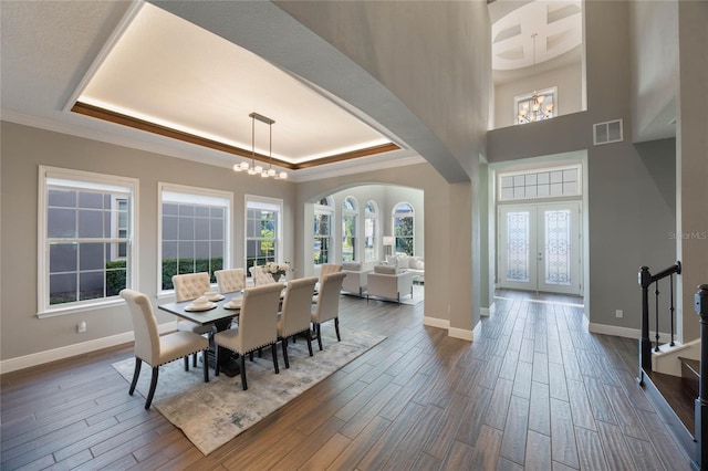 dining room featuring a raised ceiling, french doors, and wood-type flooring