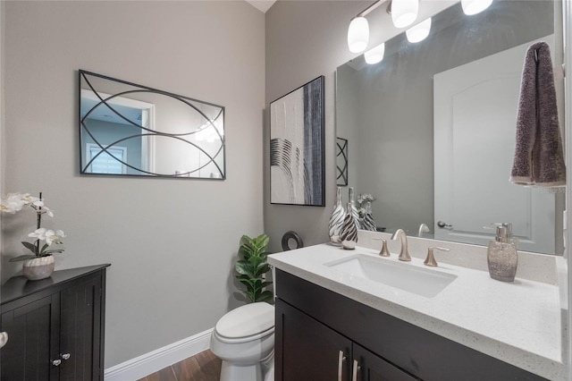 bathroom featuring vanity, wood-type flooring, and toilet