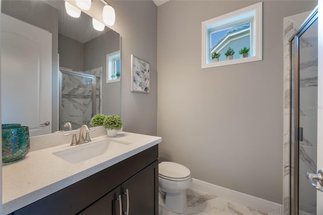 bathroom featuring a shower with door, vanity, and toilet