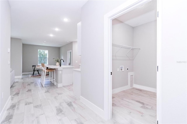 laundry area featuring hookup for an electric dryer, hookup for a washing machine, light wood-type flooring, and sink