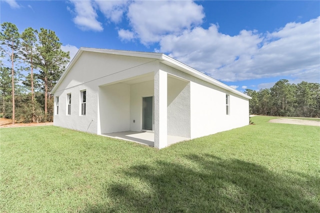 back of property with a patio area and a lawn