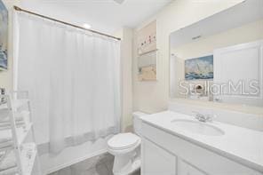 full bathroom featuring vanity, shower / bath combination with curtain, and toilet