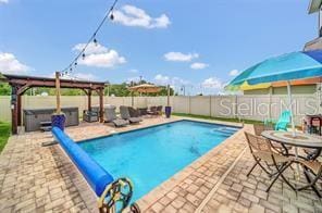 view of swimming pool featuring a patio area and a hot tub