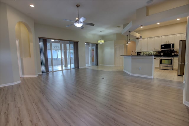 unfurnished living room featuring light wood-type flooring and ceiling fan