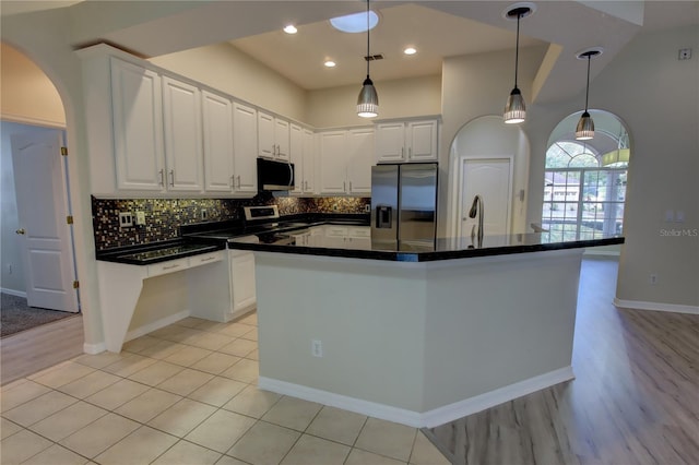 kitchen with white cabinets, a center island, stainless steel appliances, and hanging light fixtures