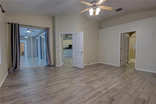 spare room featuring ceiling fan, light wood-type flooring, and lofted ceiling