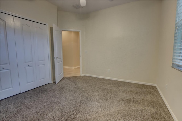 unfurnished bedroom with carpet floors, a closet, and ceiling fan