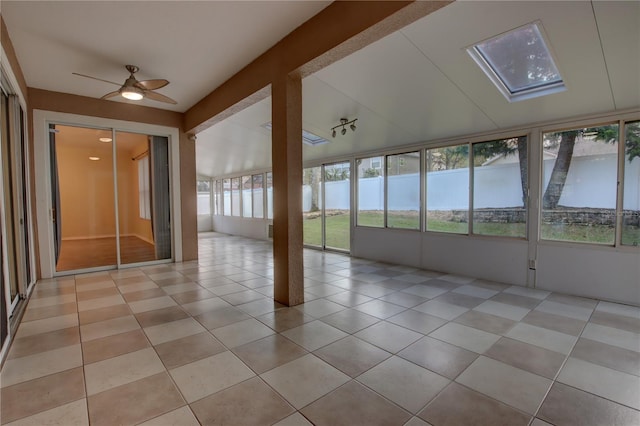 unfurnished sunroom with a skylight, ceiling fan, a water view, and a healthy amount of sunlight