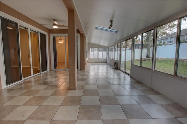 unfurnished sunroom featuring ceiling fan, a water view, and lofted ceiling