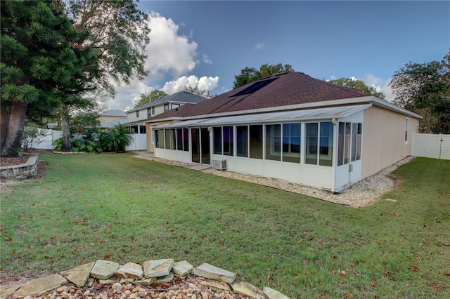 rear view of house with a sunroom and a yard