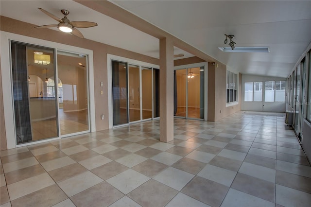 unfurnished sunroom with ceiling fan and vaulted ceiling