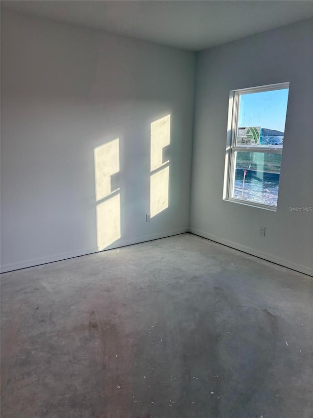 unfurnished room with concrete flooring