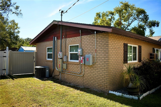 view of property exterior with a yard and central AC