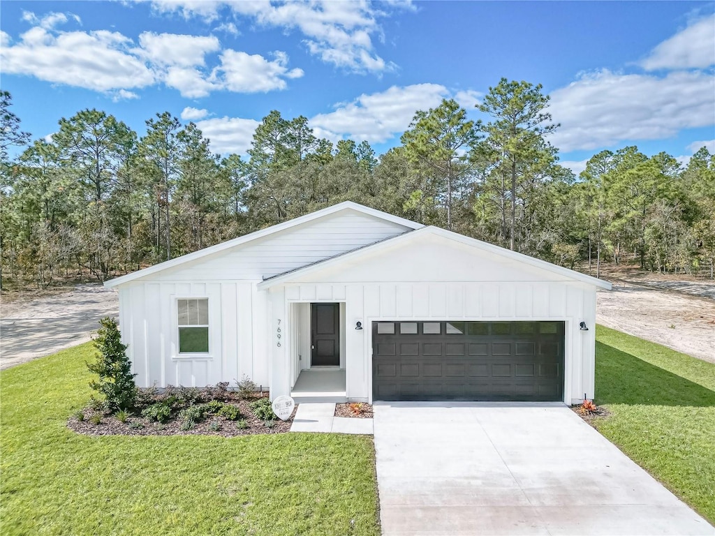 modern farmhouse featuring a garage and a front lawn