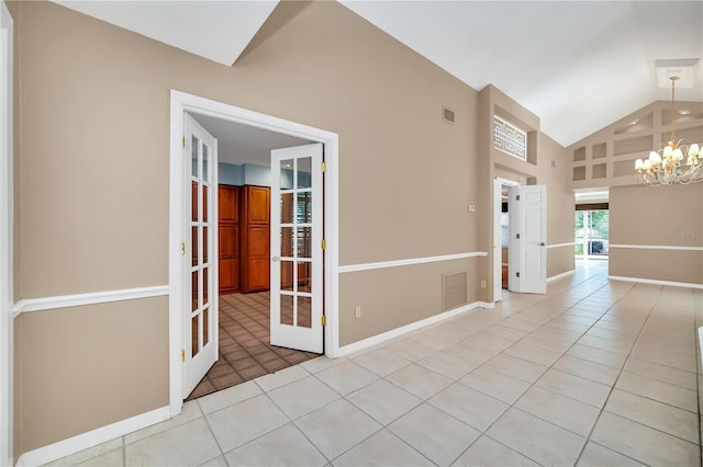 empty room with light tile patterned floors, french doors, high vaulted ceiling, and a chandelier