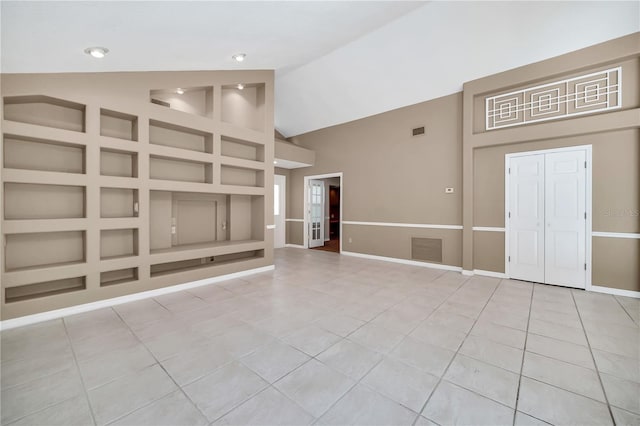 unfurnished living room with high vaulted ceiling, built in features, and light tile patterned floors