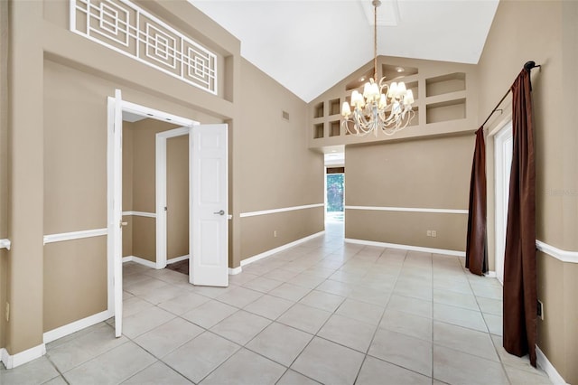 tiled empty room with high vaulted ceiling and a chandelier