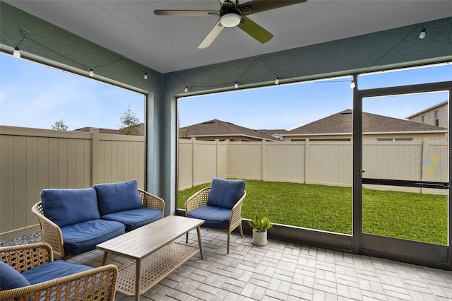 sunroom featuring ceiling fan