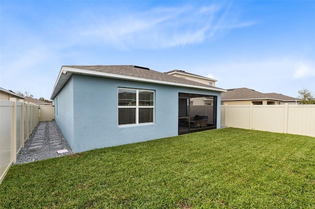 rear view of property featuring a lawn