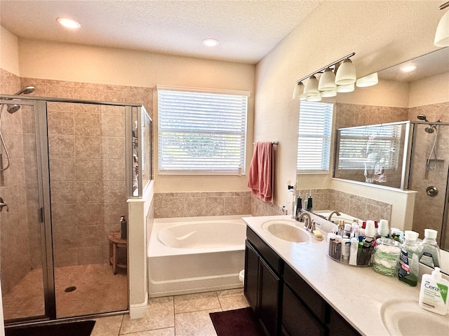 bathroom with tile patterned floors, plus walk in shower, vanity, and a textured ceiling