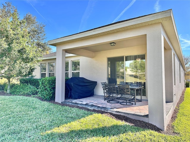 rear view of property with a lawn and a patio area