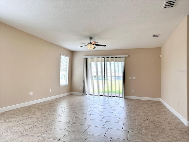 empty room featuring visible vents, baseboards, a textured ceiling, and ceiling fan