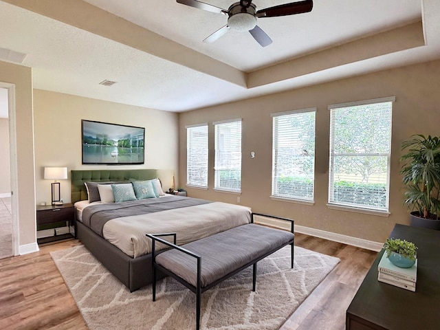 bedroom with light wood-style flooring, multiple windows, and visible vents