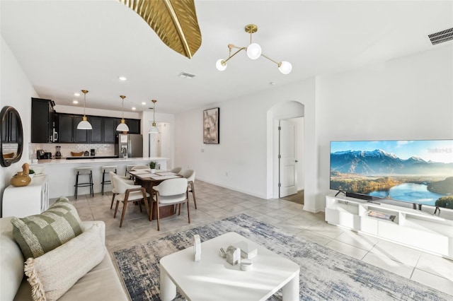 living room with a chandelier and light tile patterned floors