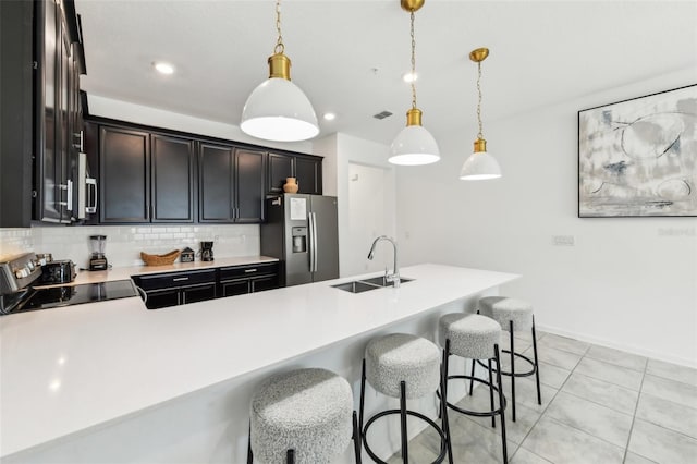 kitchen featuring decorative backsplash, decorative light fixtures, stainless steel appliances, and sink