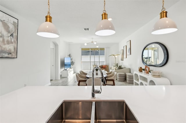 kitchen featuring light tile patterned floors, hanging light fixtures, and sink