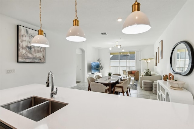 kitchen featuring sink, light tile patterned floors, and decorative light fixtures