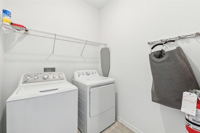 laundry area featuring light tile patterned floors and washer and clothes dryer