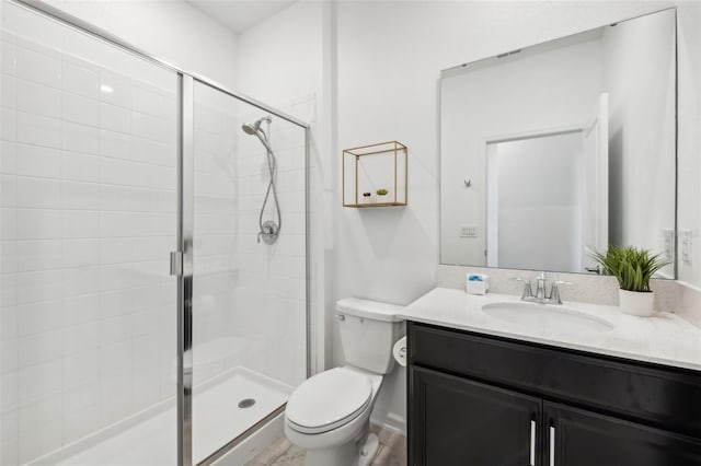 bathroom with vanity, toilet, and a shower with door