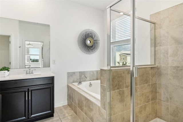 bathroom with tile patterned flooring, vanity, independent shower and bath, and a healthy amount of sunlight