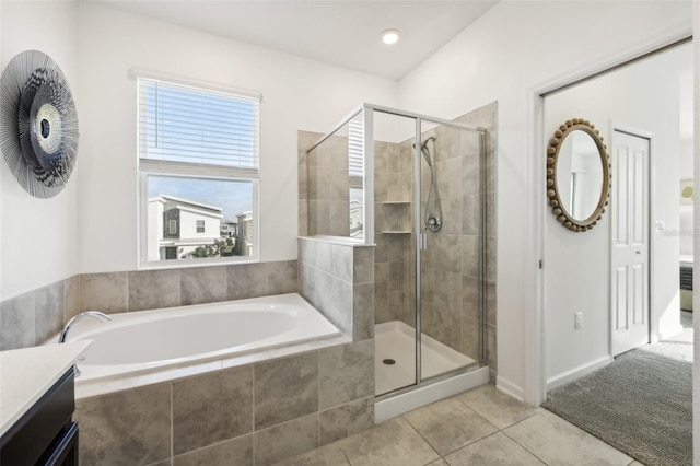 bathroom with vanity, tile patterned flooring, and plus walk in shower