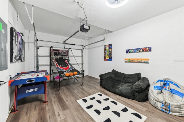 game room with hardwood / wood-style flooring and a textured ceiling